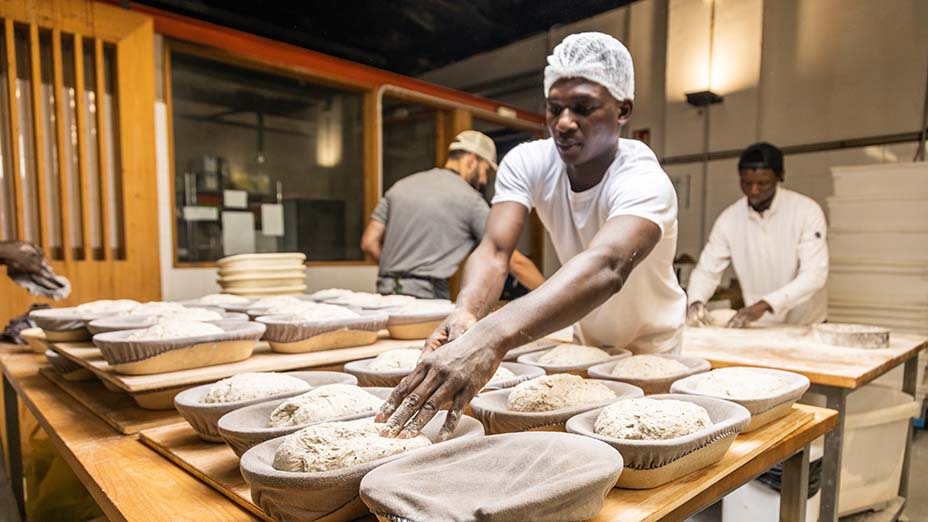 bakers working in a bread factory teaching apprentices