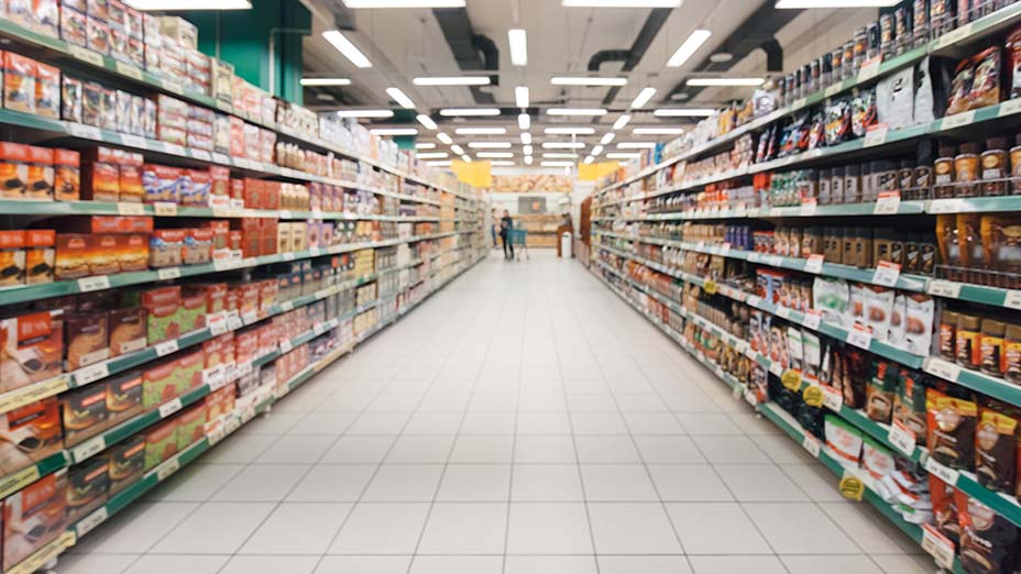 blurred supermarket aisle with full colourful shelves