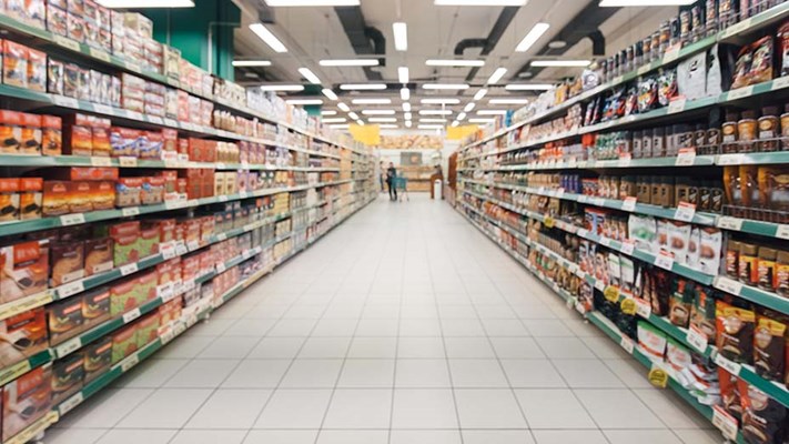 blurred supermarket aisle with full colourful shelves