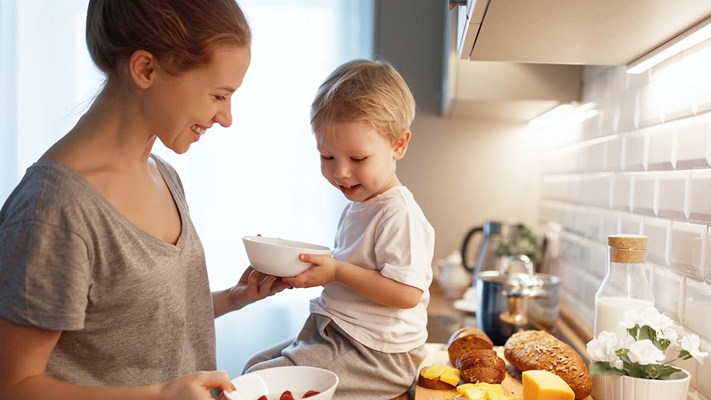 mother and baby son cook porridge in morning