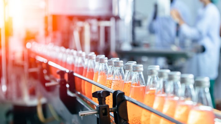 Drink factory production line fruit juice beverage product at conveyor belt.