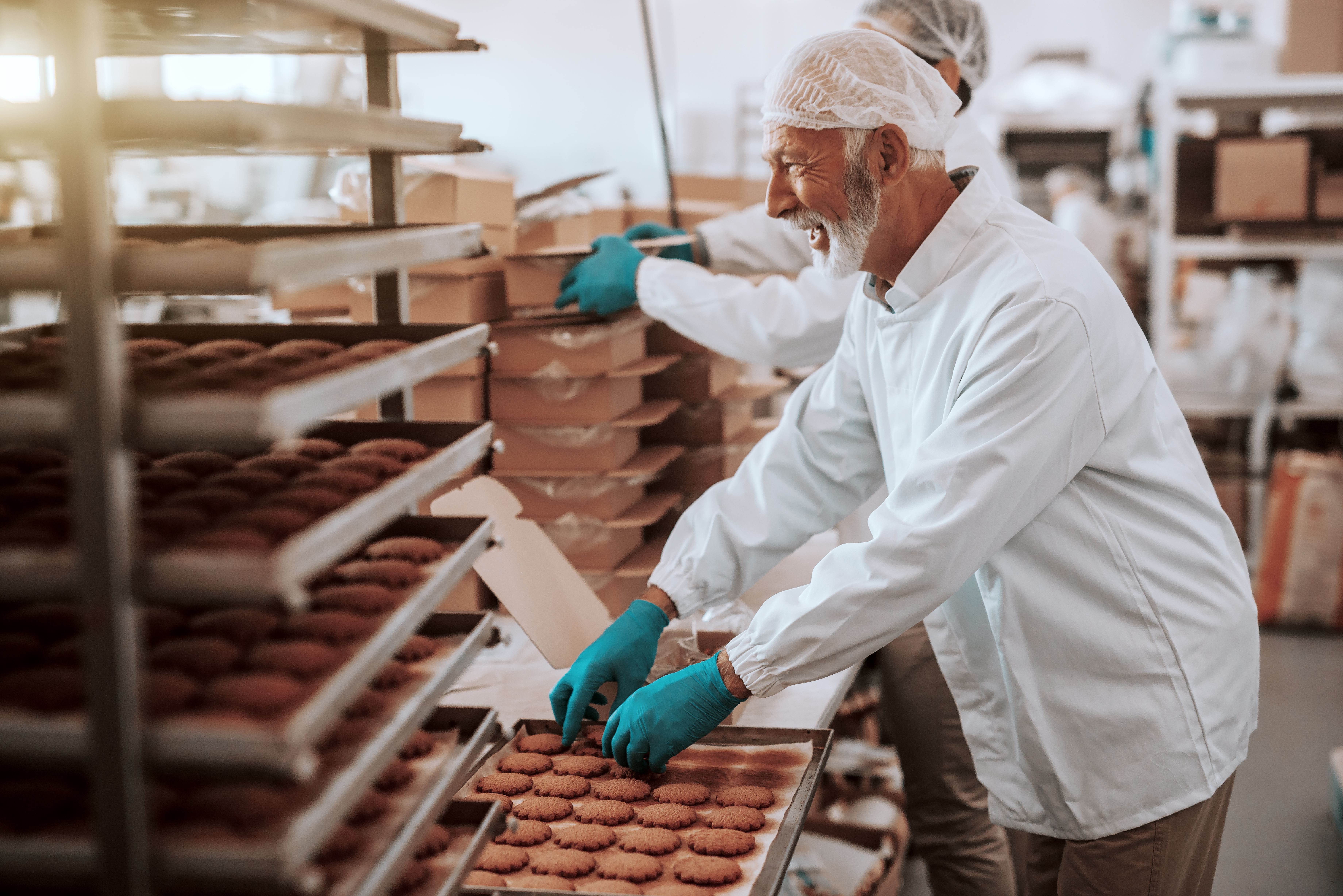 Two hardworking employees packing cookies in boxes