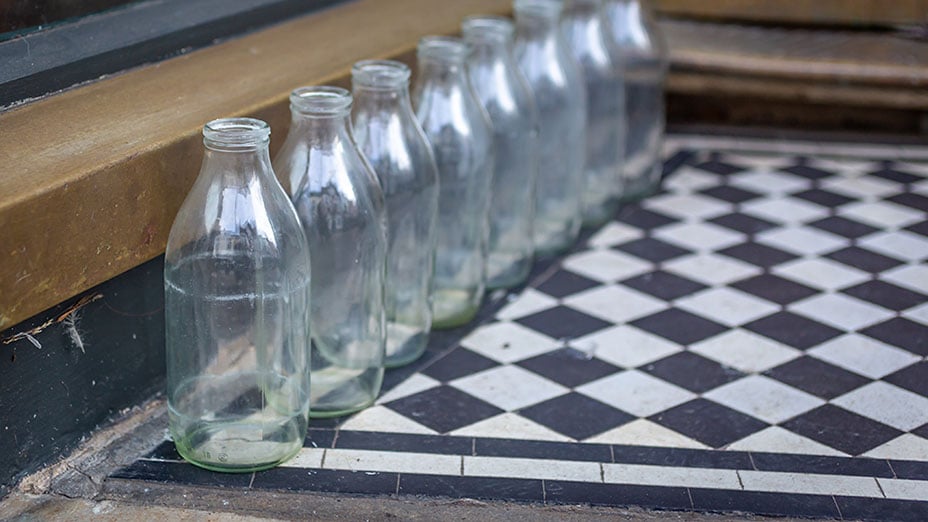 Empty milk bottles on a doorstep awaiting collection