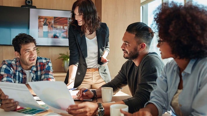 Team of colleagues brainstorming in meeting room with color palettes