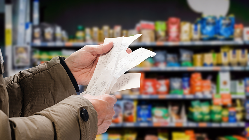 man viewing receipts in supermarket and tracking prices