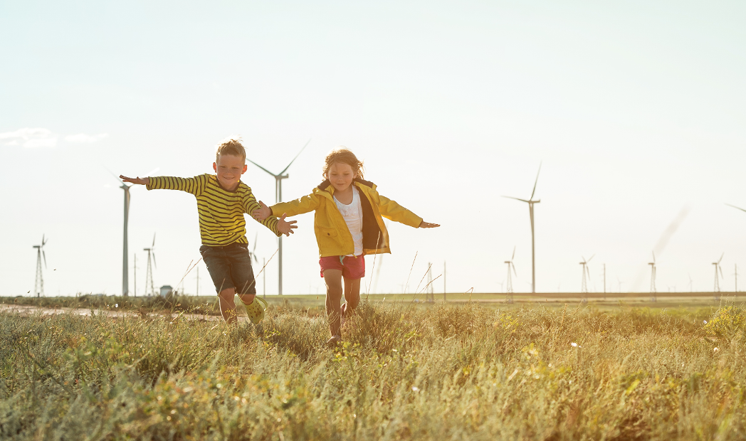 Sustainability Ambition 2025  -  children playing near wind turbines