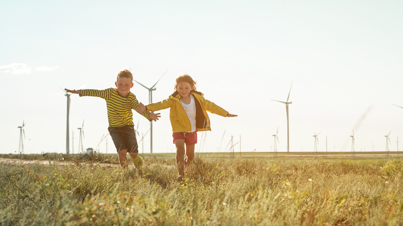 Sustainability Ambition 2025 - children playing near wind turbines