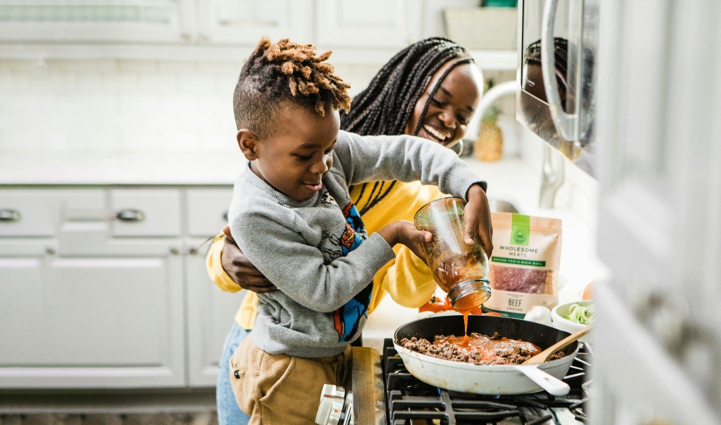 mother and young boy enjoy cooking together in family kitchen - card