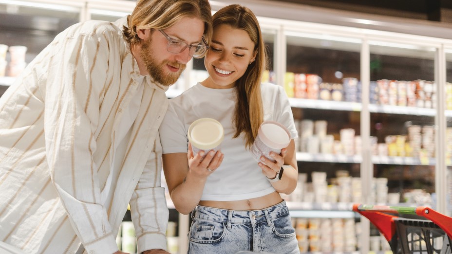 young couple shopping for groceries reading product labels