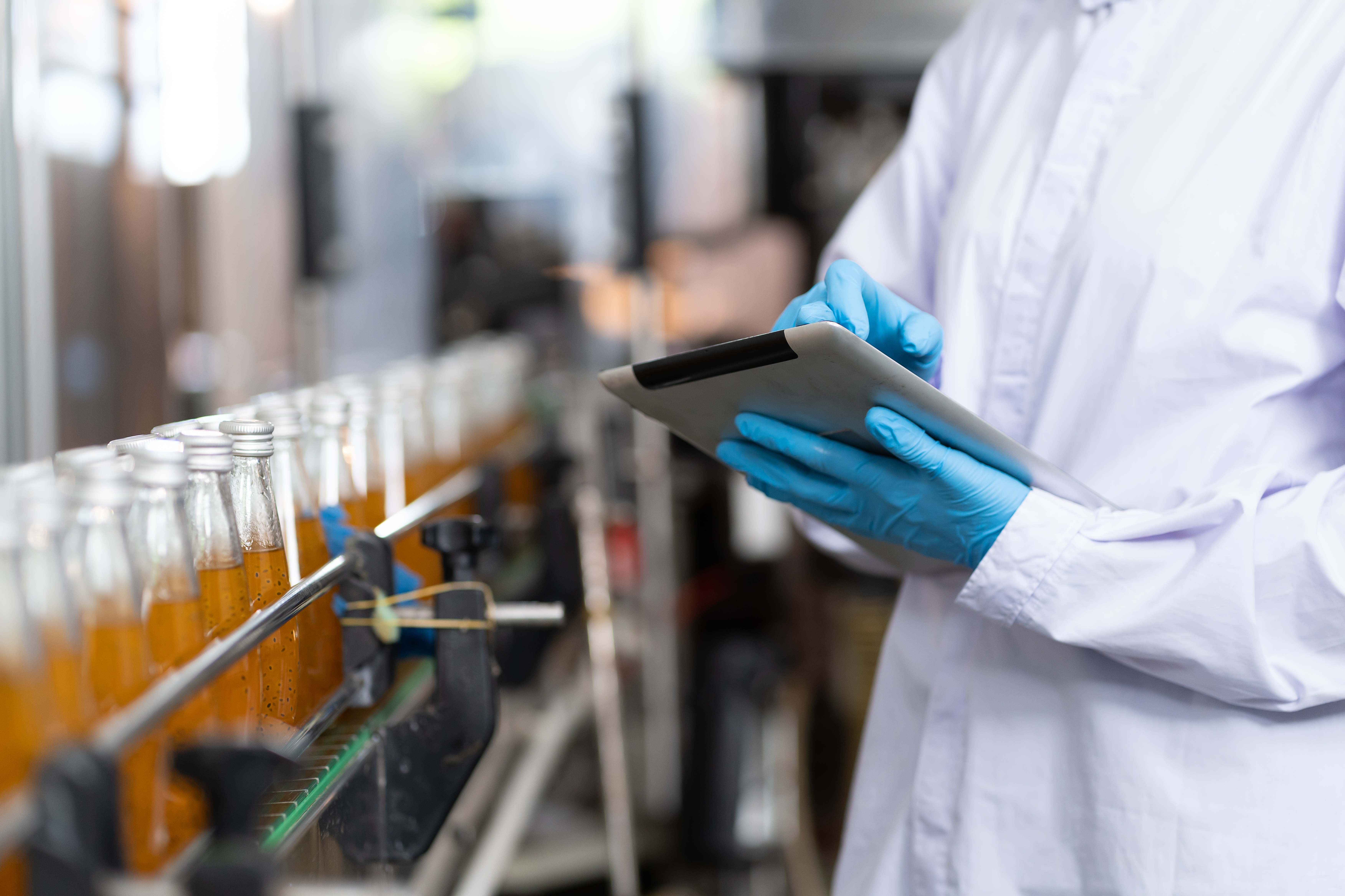 Checking bottled fruit juice on conveyor belt in beverage factory